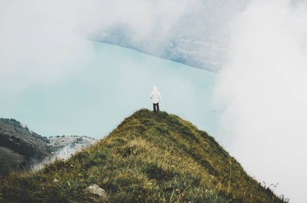 person standing on green grass mountain